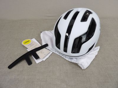 Le casque est blanc et comporte des bandes noires.