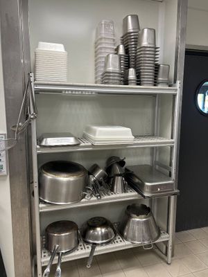 de nombreuses casseroles et poêles sur les étagères de la cuisine