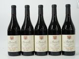 six bottles of red wine are lined up on a table