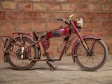 a red motorcycle parked in front of a brick wall