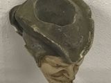 a stone skull hanging from a hook on a wall