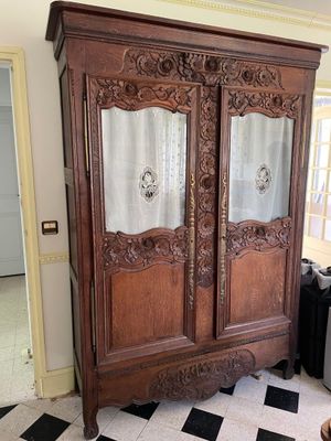 a large wooden armoire in a room with a checkered floor