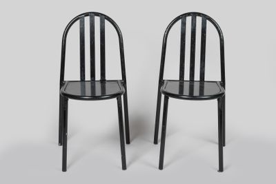 deux chaises noires placées l'une à côté de l'autre sur une surface blanche