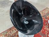 une chaise noire posée sur un tapis rouge dans un salon