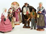 five figurines of people dressed in historical clothing