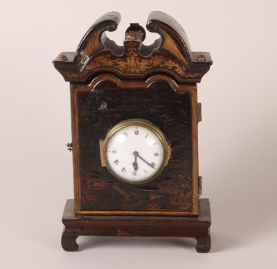 une petite horloge en bois surmontée d'un oiseau