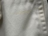 the back of a white shirt with a button on it
