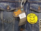 a blue jean jacket with a yellow badge on it