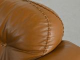 a close up of a brown leather couch with stitching on it