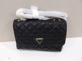 black quilted purse with a white scarf on top of it