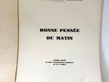 un livre ouvert posé sur une table blanche, à côté d'une paire de ciseaux