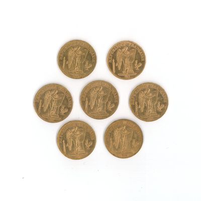 six pièces d'or de tailles et de formes différentes sur une surface blanche