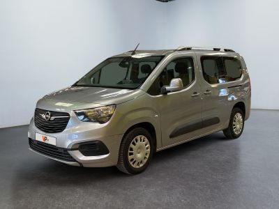 La camionnette argentée est garée dans une grande pièce aux murs blancs.