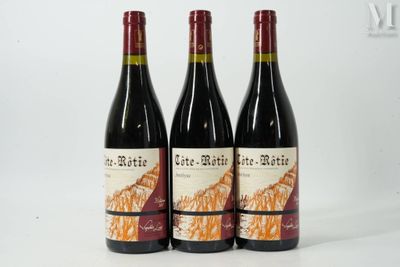 trois bouteilles de vin rouge posées sur une table blanche