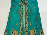 une robe verte ornée de broderies dorées et bleues