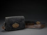 une paire de sacs à main en cuir noir et marron posés sur une surface grise