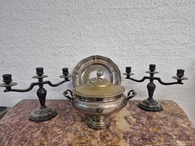 un bougeoir en argent et en or posé sur une table en marbre