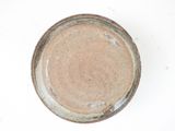 a brown plate with a brown rim on a white surface