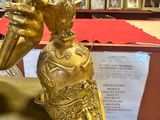a gold statue of a hand holding a vase