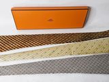 three ties and a box are sitting on a white surface
