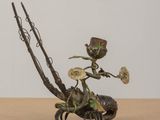 sculpture en bronze représentant une femme assise sur un crabe, tenant une fleur à la main