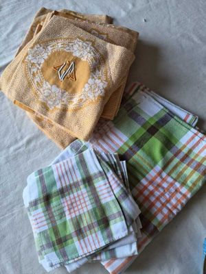Plusieurs serviettes sont disposées sur un lit ; elles portent un monogramme.