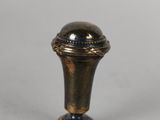 an antique brass door knob with a blue stripe on the top