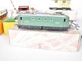 a green train on a box next to other toy trains