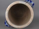 a blue and white vase sitting on a gray surface