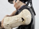 a figurine of a man sitting on a stool
