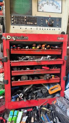 un établi rouge sur lequel sont posés des outils, dans un garage