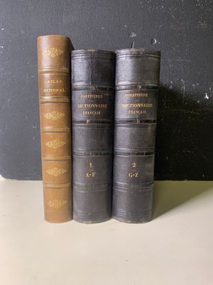trois vieux livres posés sur une table l'un à côté de l'autre