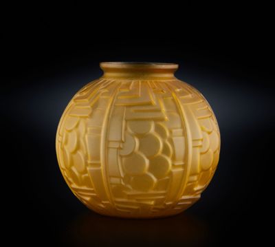 un vase jaune posé sur une table, sur fond noir