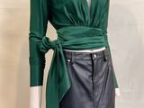 the dress is green and black with a belt on the waist