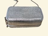 a silver purse that is sitting on a table