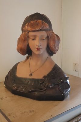 a bust of a woman sitting on top of a wooden table