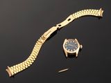 an image of a gold watch and a gold bracelet on a black surface