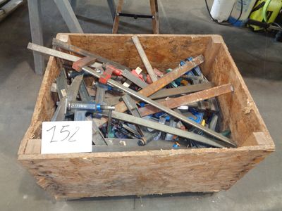 une caisse en bois remplie d'outils divers, posée par terre