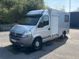 un petit camion blanc garé sur un parking