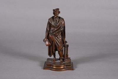 bronze statue of a man with a suitcase and a hat