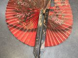 a red fan with a pair of scissors on top of it