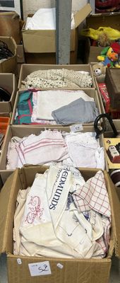 de nombreux cartons contenant des vêtements et d'autres objets, posés par terre