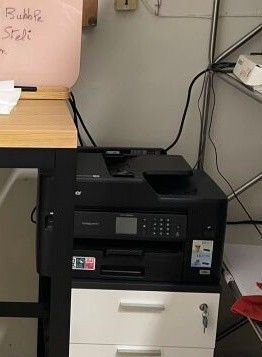 une imprimante posée sur un bureau à côté d'une imprimante