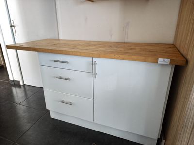 une armoire blanche avec un plan de travail en bois dans une cuisine