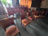 de nombreuses chaises en bois dans une pièce dotée de nombreuses fenêtres