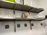 une étagère en métal sur laquelle sont posés des plats, dans une cuisine