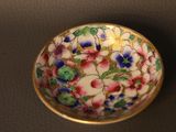 a small bowl with flowers on it on a table