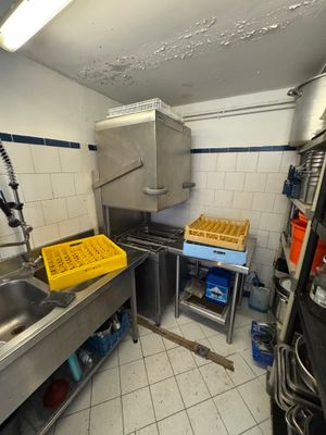 a kitchen with a sink, stove, and other items in it
