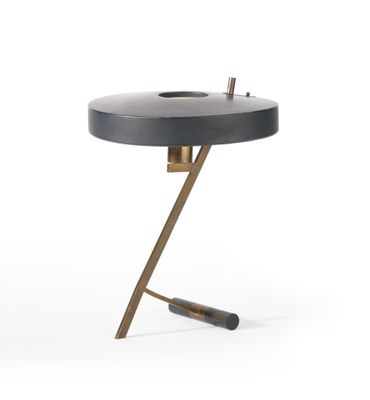 une table noire et dorée avec un piètement en métal et un plateau noir