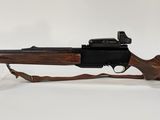 un fusil sur fond blanc, posé dans un support en plastique transparent